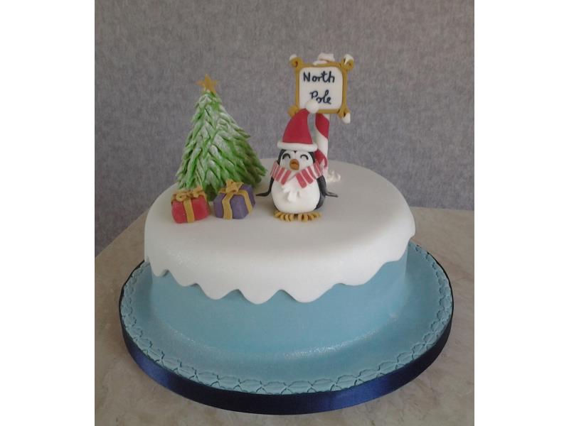 Penguin and presents with snow scene for Christmas cake in vanilla sponge.