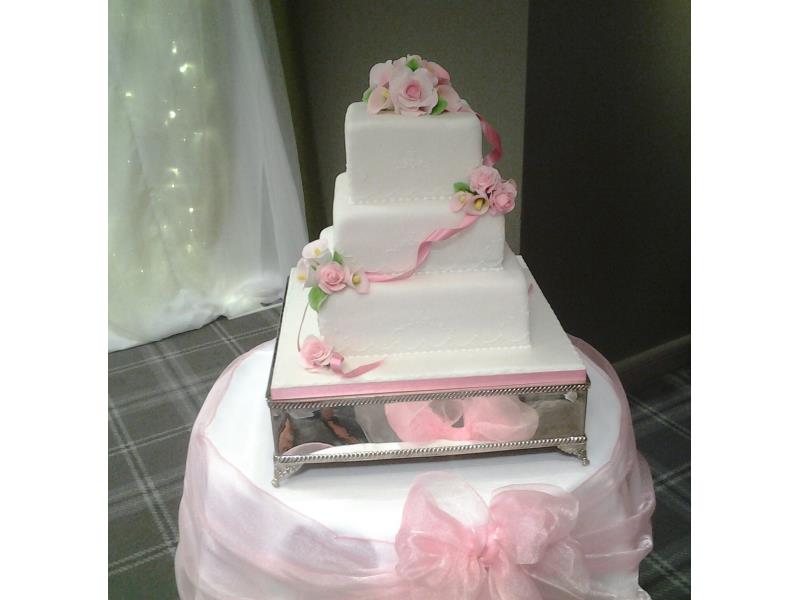Calla Lillies on 3 tier pink and white wedding cake for Lisa & Alex at Village Hotel Blackpool. Handmade lillies on vanilla and lemon sponges.