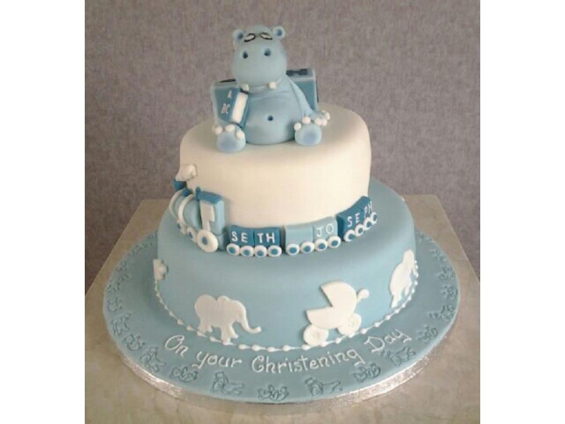 2 tier Chistening cake with elephant and train together with silhouettes. Sponges are lemon and chocolate with orange. For Seth Joseph in Cleveleys.