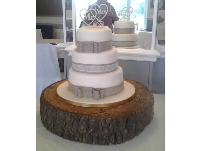 3 tier Hessian wedding cake on rustic log. Plain and classic in design with clients choice of topper. Made from vanilla, chocolate and lemon sponges.