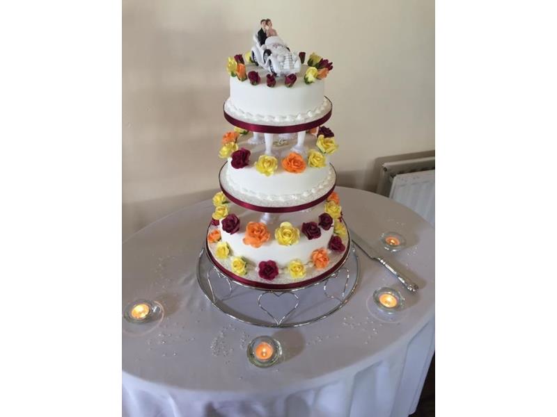 Fresh and clean lines for this 3 tier wedding cake with pillars. Personalised topper with bridal couple in car