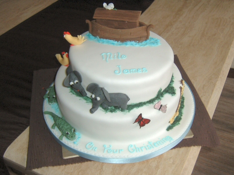 Milo - 2 tier stacked christening cake with hand modelled suger animal decoration depicting the Ark and animals arriving two by two