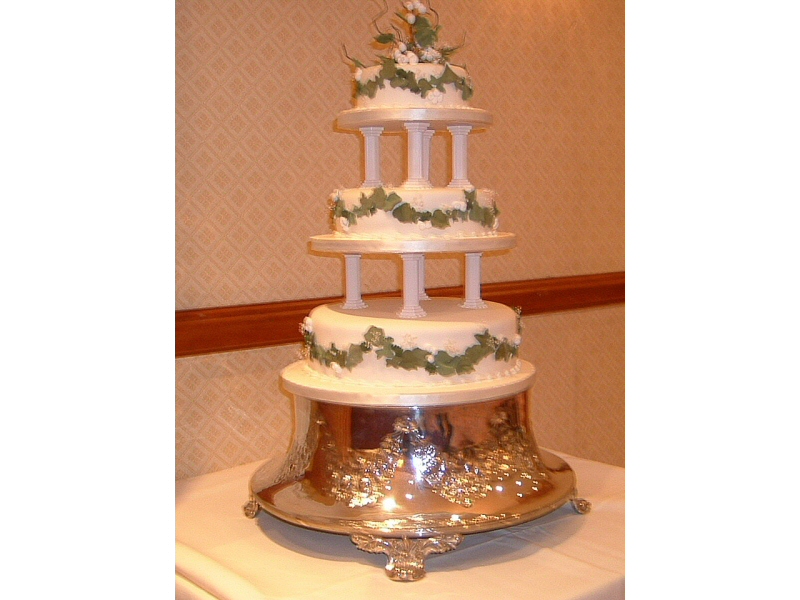 Julie - 3 tier cream pillared wedding cake with garlands of ivy leaves and berries