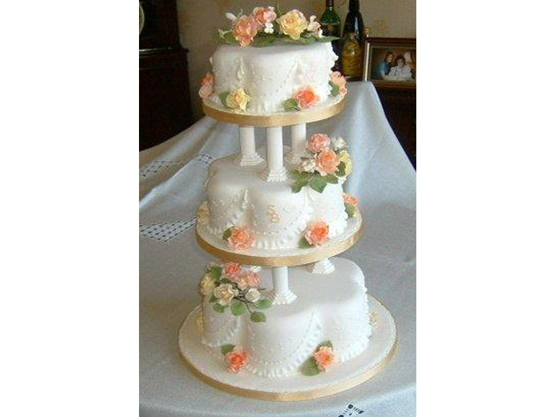 Sandra - 3 tier cream petal shaped cake with roses frilling, together with monograms of the bride and groom